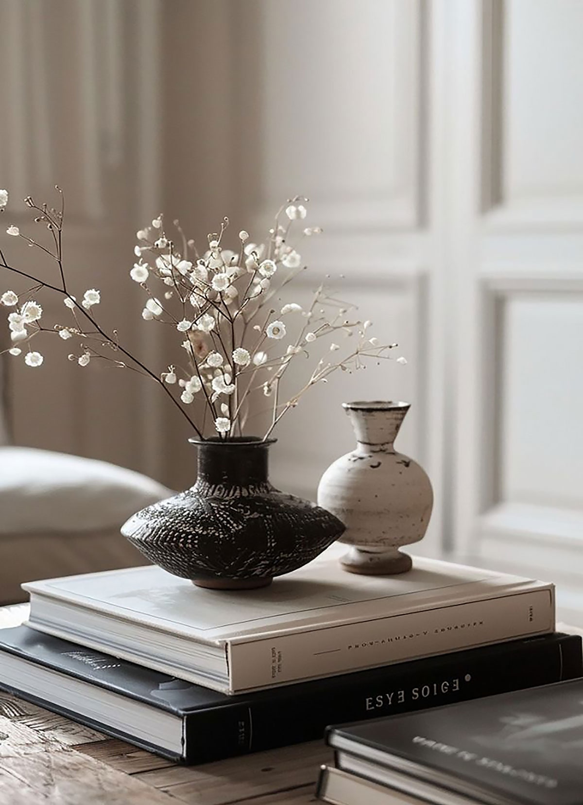 Ceramic vases and coffee table books on a timber surface